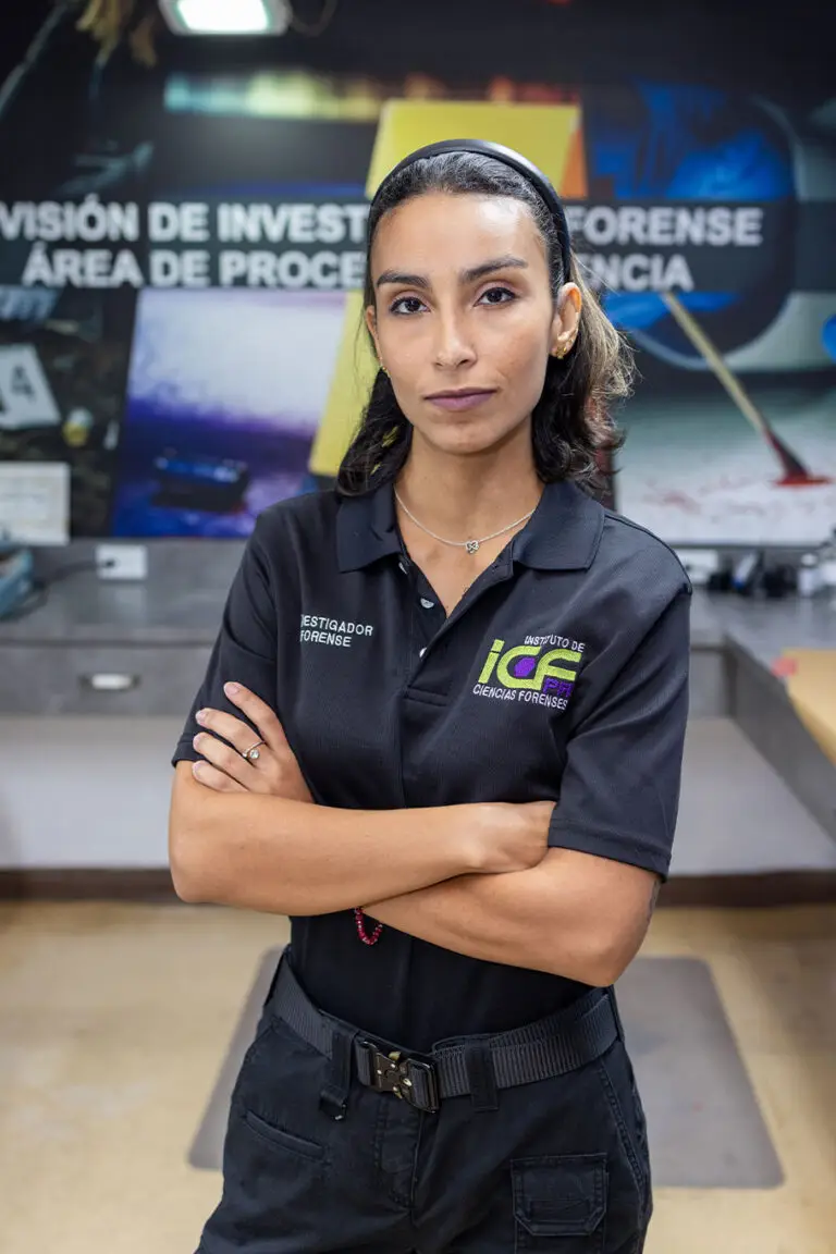 A woman in a black uniform stands with arms crossed